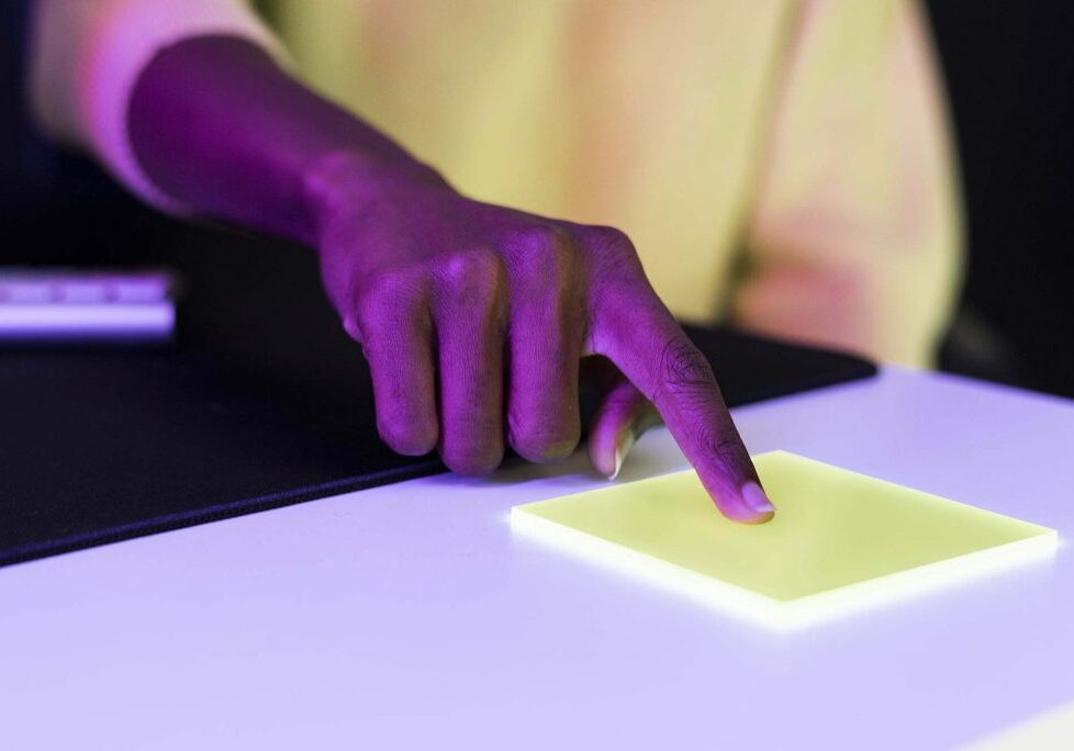 Index finger pressing on yellow transparent plate smart technology